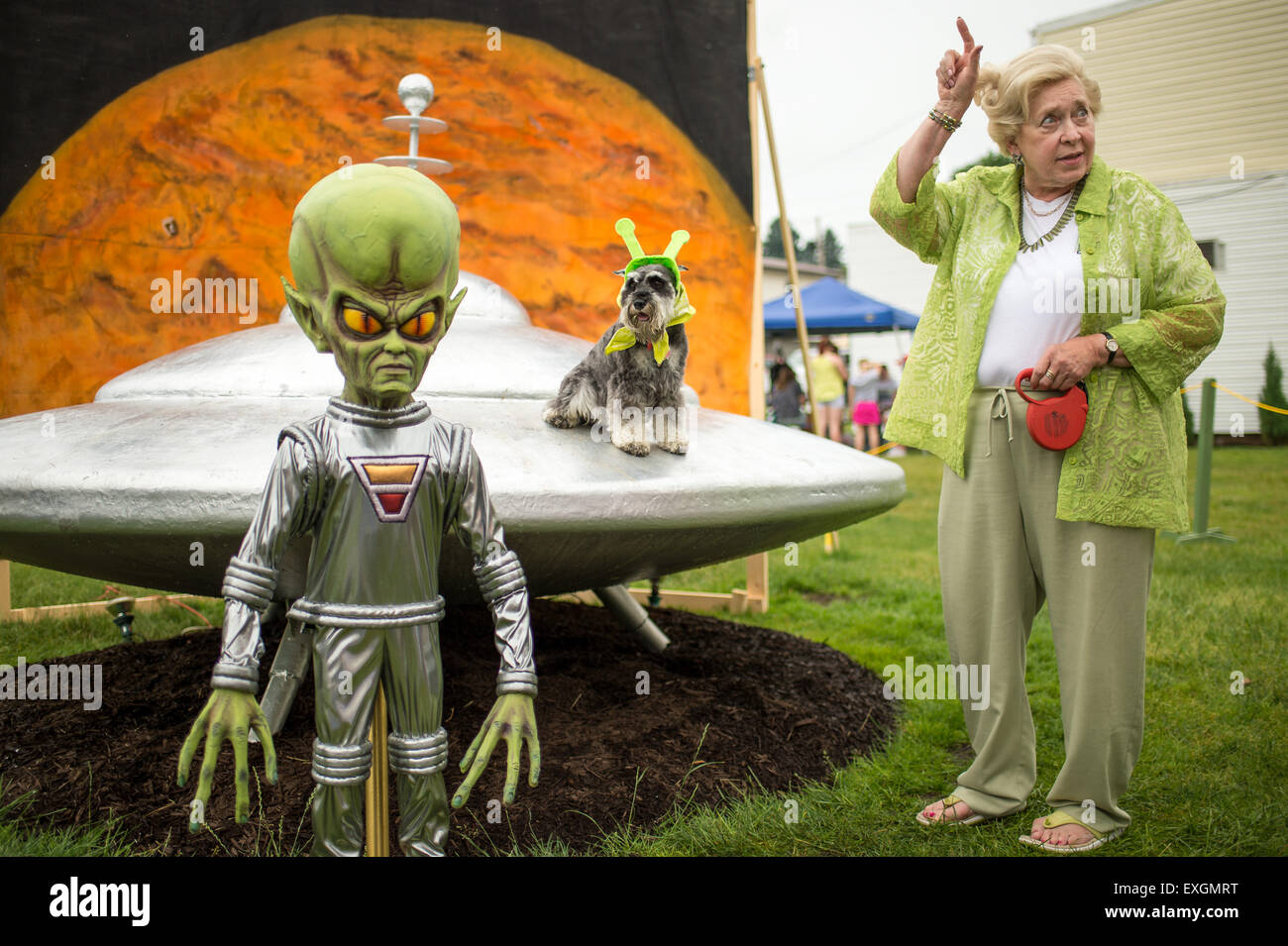 Sue Morris and her dog &quot;Pepper&quot; are seen with a model of a spacecraft and alien used for photos during the Mars New Year's celebration Saturday, June 20, 2015, in Mars, Pennsylvania. The town is hosting three days of Science, Technology, Engineering, Arts and Mathematics (STEAM) activities. Stock Photo