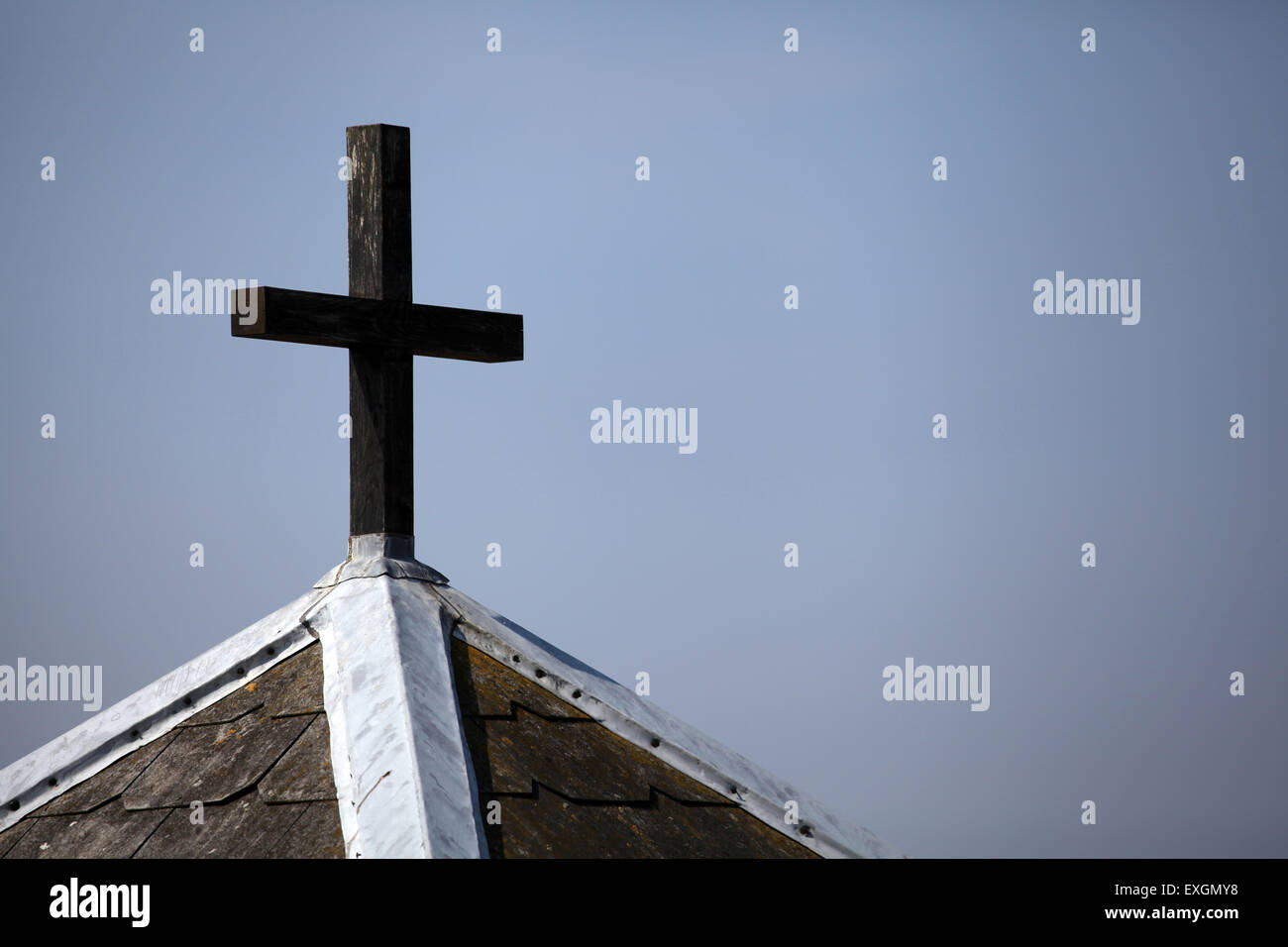 Cross on chapel against greyish sky Stock Photo