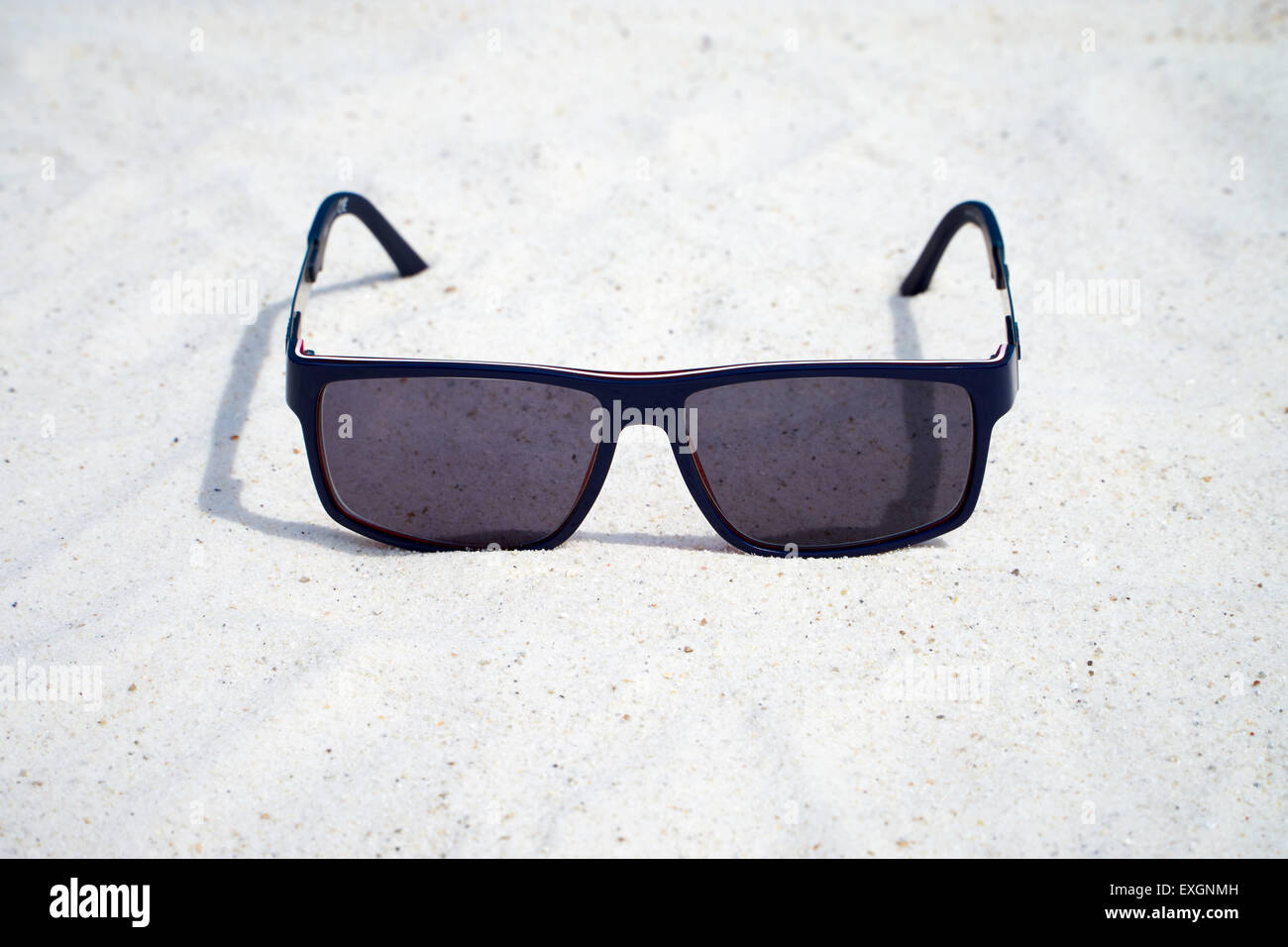 Dark Sunglasses in the sand Stock Photo