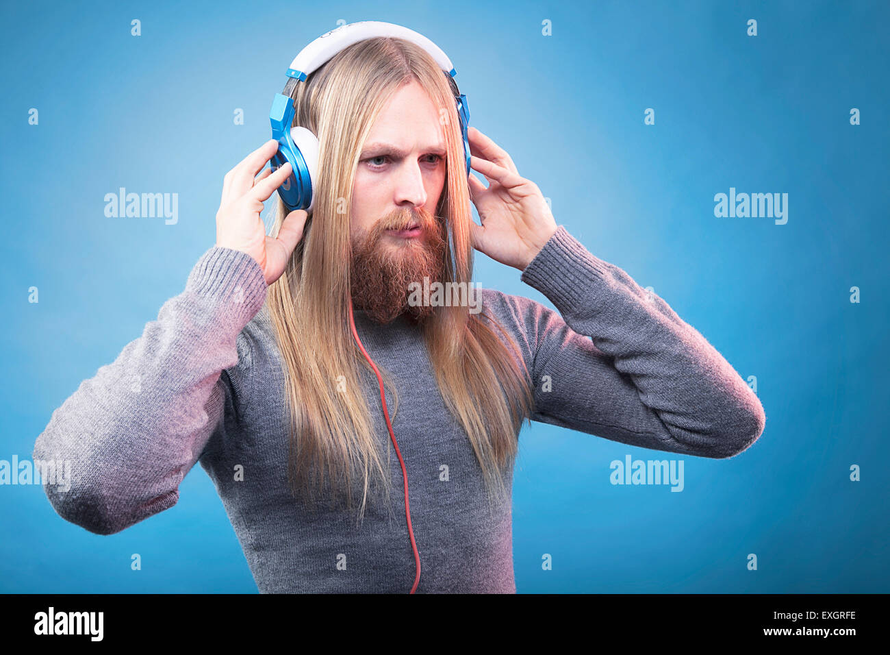 Young bearded man listens music. Stock Photo