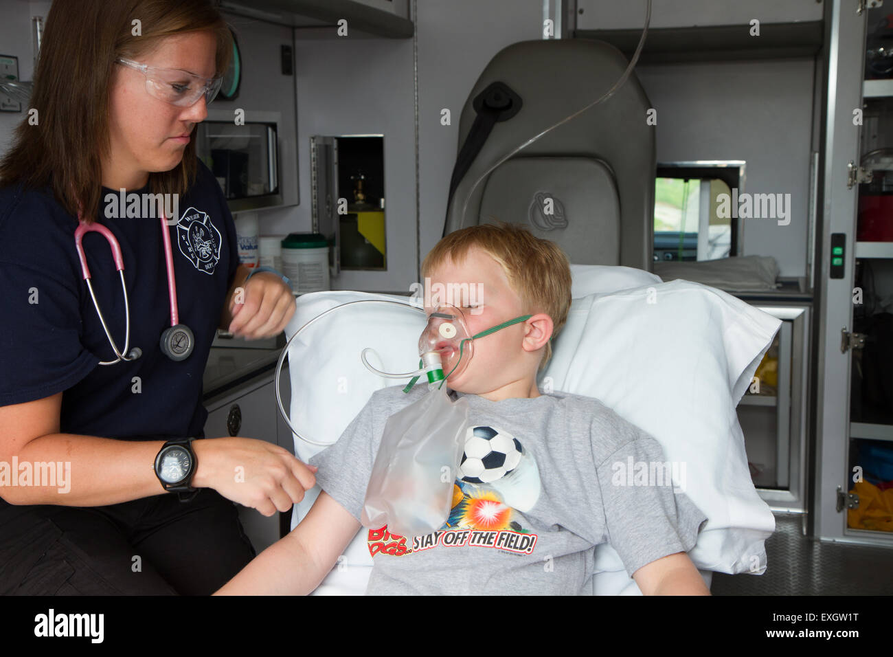 Female paramedic assisting young male patient in back of ambulance. Stock Photo