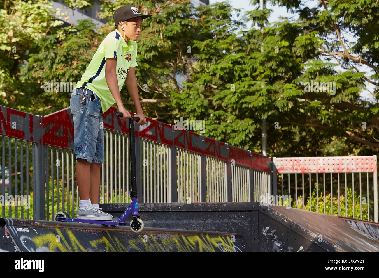 Boy On A Kick Scooter Waits At The Top Of A Ramp At The SCAPE Skate