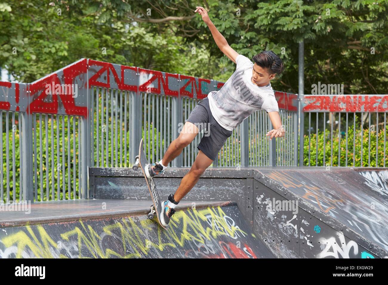 Young Oriental Man Skateboarding in the SCAPE Skate Park, Singapore