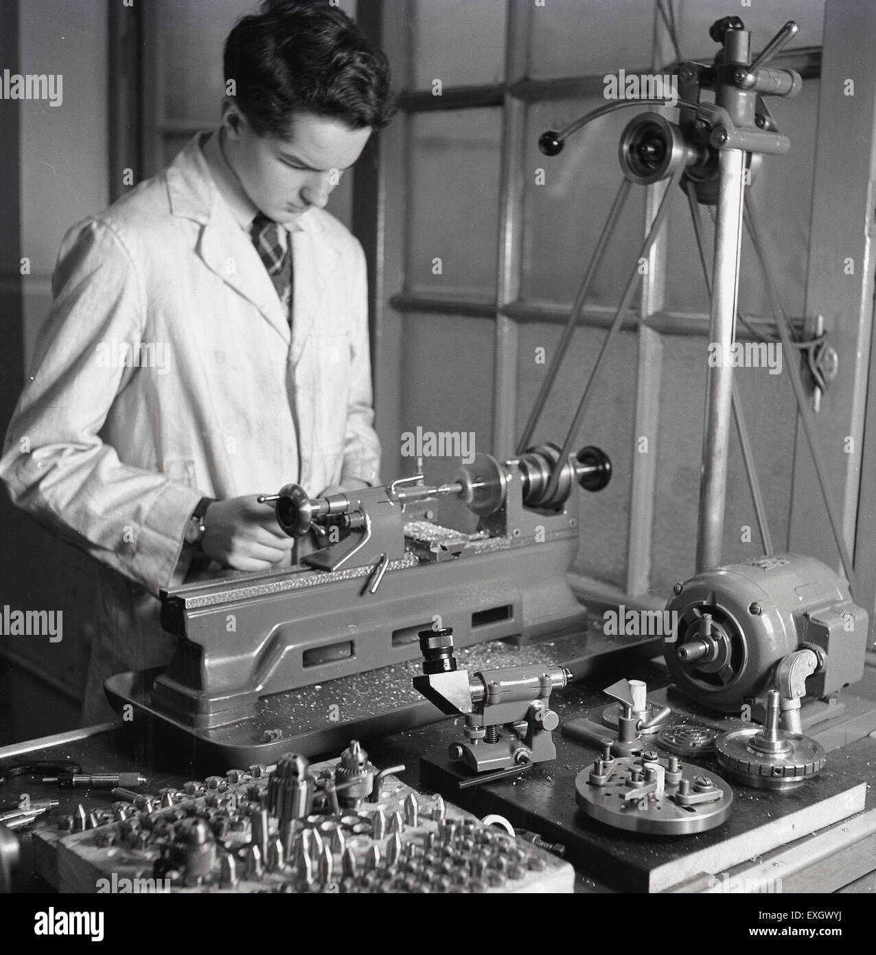 1950s historical picture of a young male engineer using a metal cutting