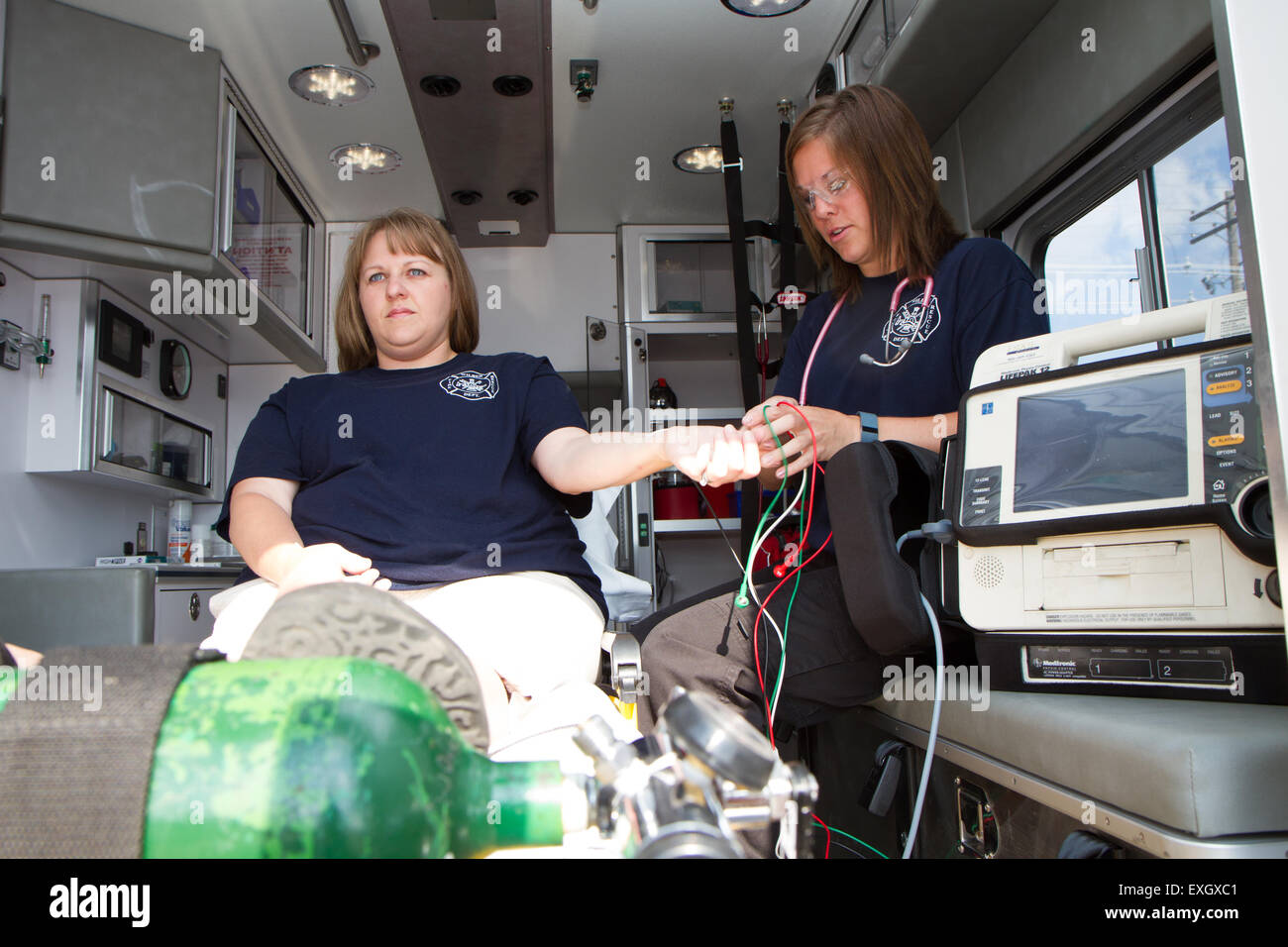 Female paramedics working in the back of an ambulance. Rural volunteer US fire department. Stock Photo