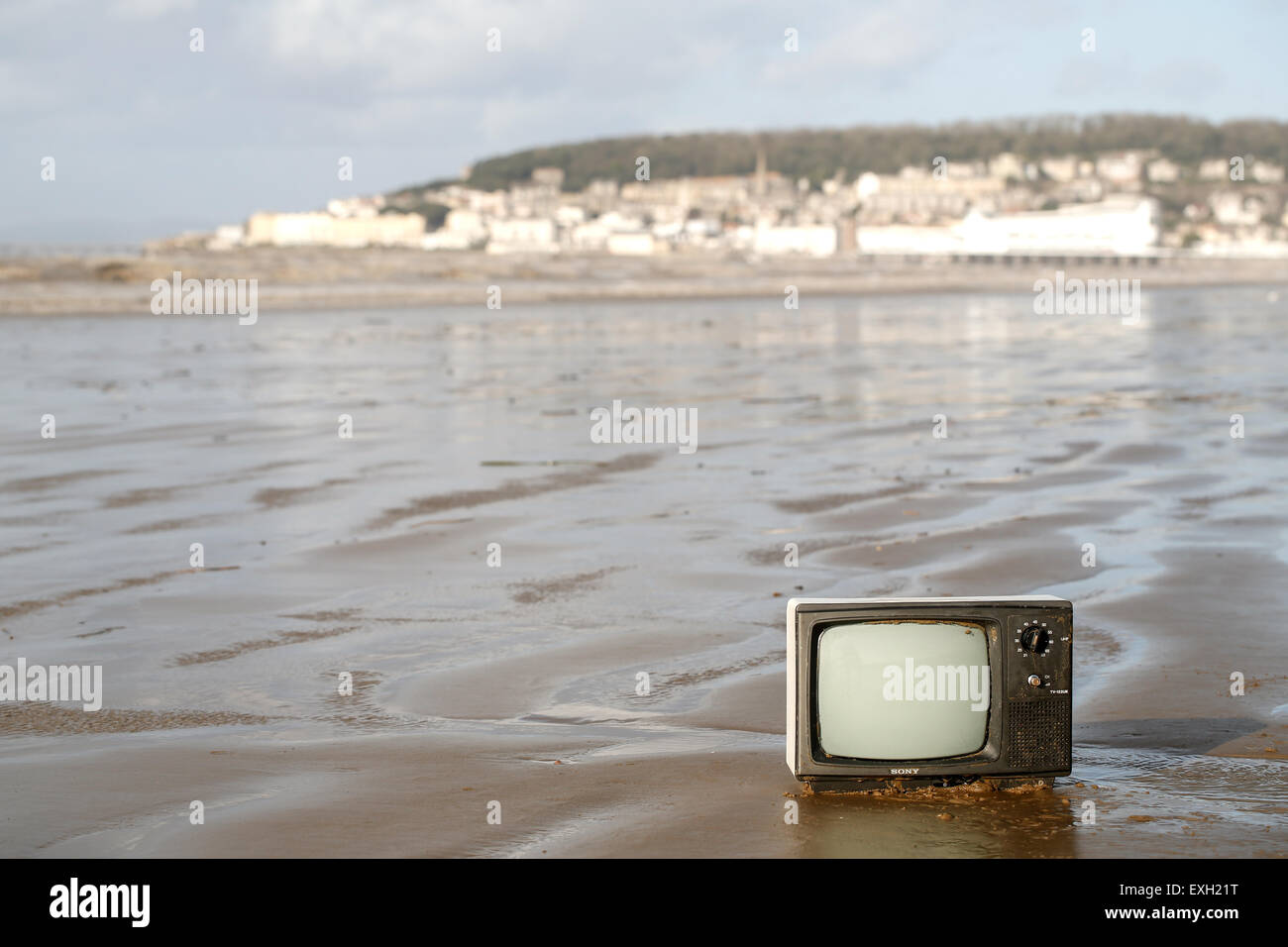 An old TV, washed up out of the sea onto an English sandy shoreline. Environmentally damaging to the beach at weston super mare, UK Stock Photo