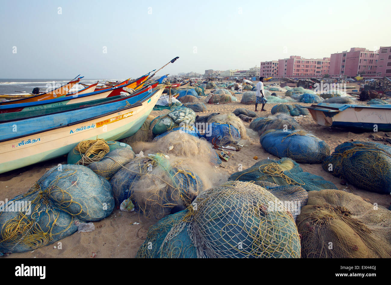 Wooden fishing boats and nets on the beach in Chennai, India Stock