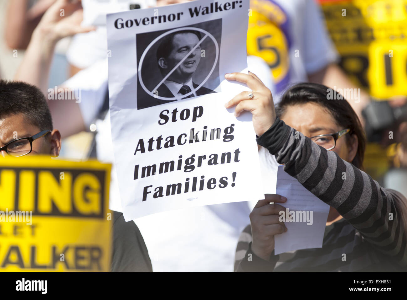 Waukesha, Wisconsin, USA. 13th July, 2015. A woman holds a pro-immigration protest sign in front of the Waukesha Convention Center in Waukesha, Wisconsin where Governor Scott Walker is about to make an annoucement that he will run for President in the 2016 United States Presidential election. Credit:  Julia Hansen/Alamy Live News Stock Photo