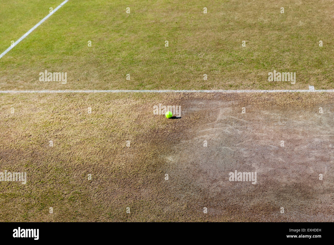 Tennis ball lying still on a well-used grass court on the finals weekend of the Wimbledon 2015 championships Stock Photo