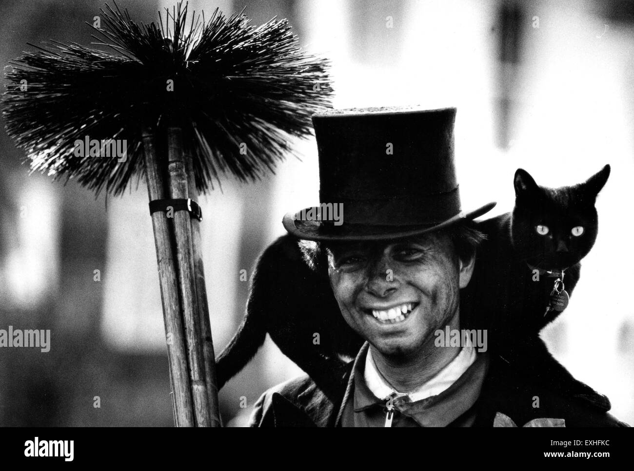 Chimney sweep with brush and black cat on his shoulder 1980s Stock Photo