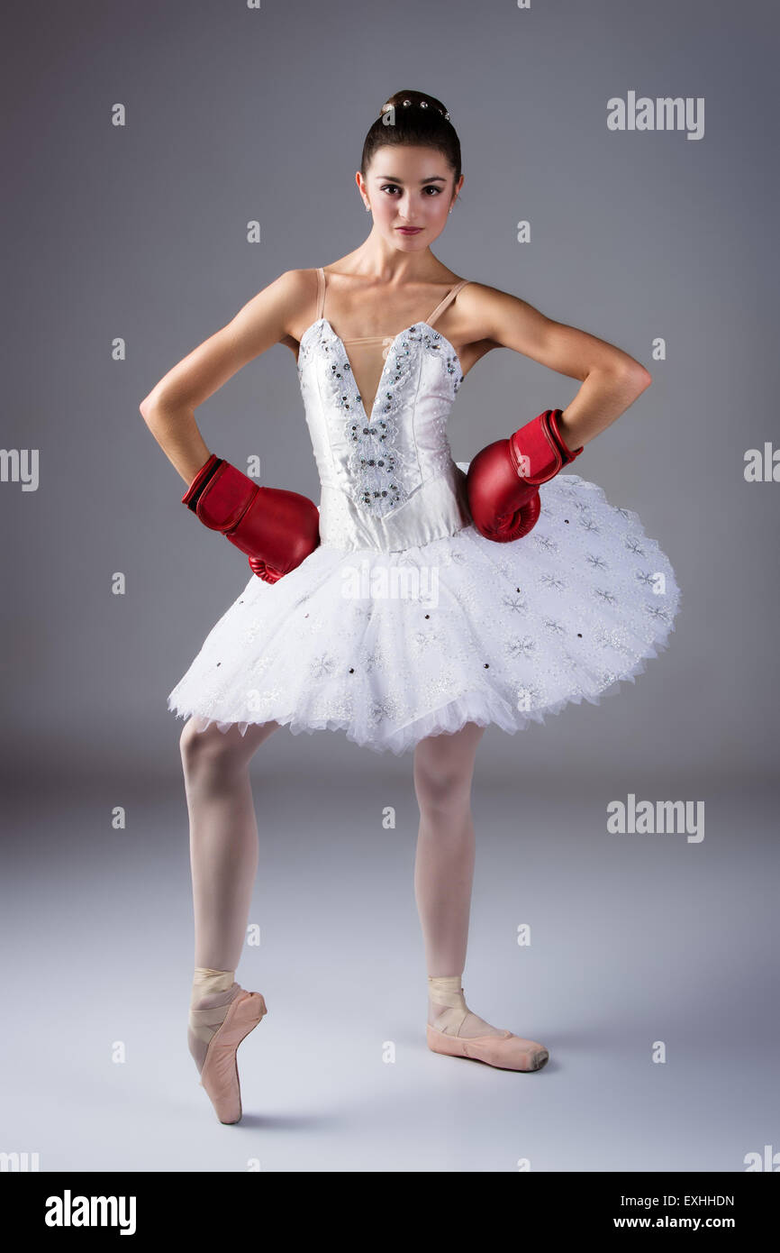 Beautiful female ballet dancer on a grey background. Ballerina is wearing a  white tutu, pointe shoes and red boxing gloves Stock Photo - Alamy