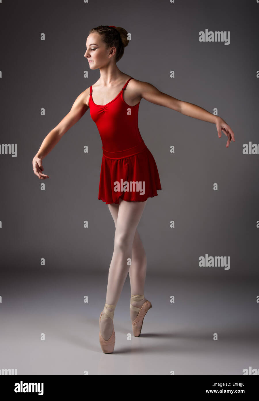 Vil have Bror Instrument Beautiful female ballet dancer on a grey background. Ballerina is wearing a  red leotard, pink stockings, pointe shoes and a red Stock Photo - Alamy