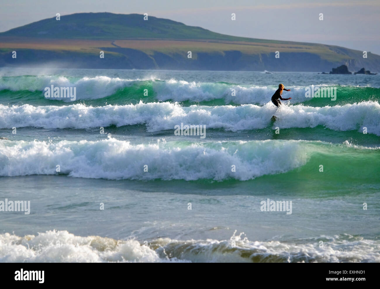 surfing at Whitesands beach near St Davids in Pembrokeshire, West  Wales, with Ramsey Island in the distance. Stock Photo