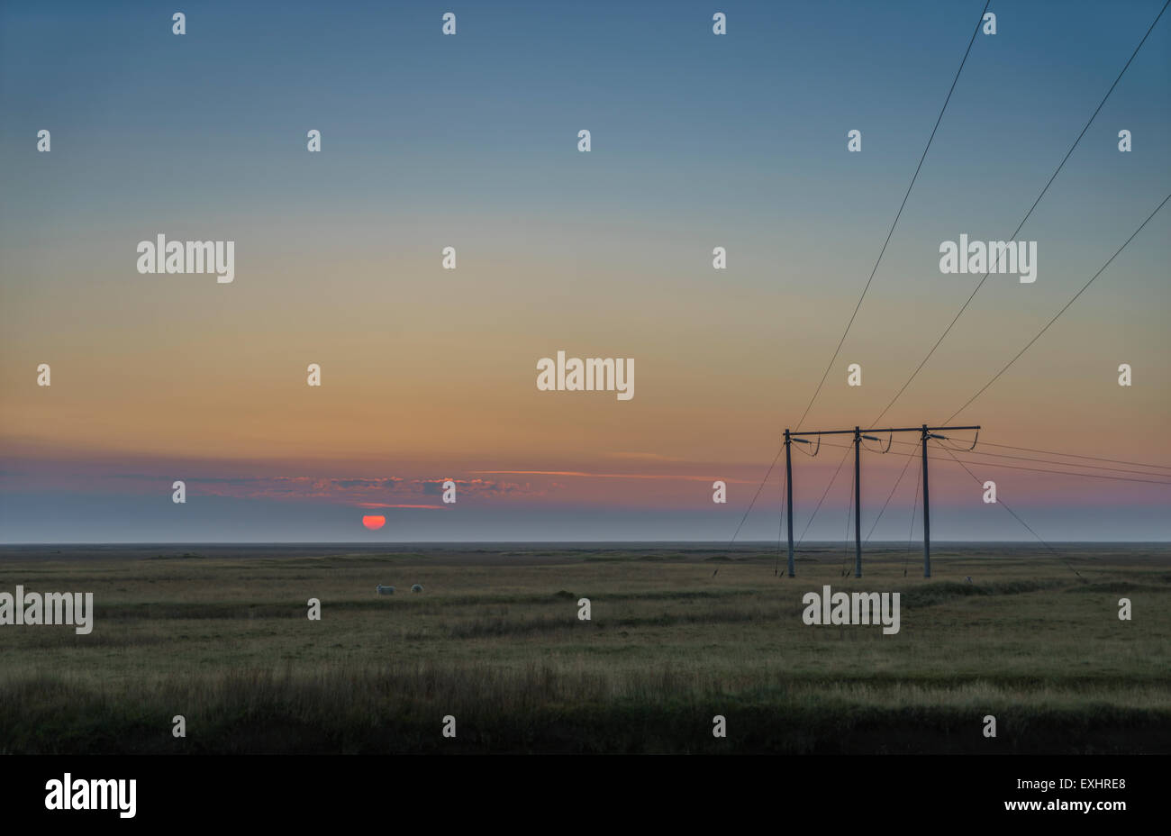 Sunset over farmland with electrical poles and wires, Skeidararsandur outwash plains, Iceland Stock Photo