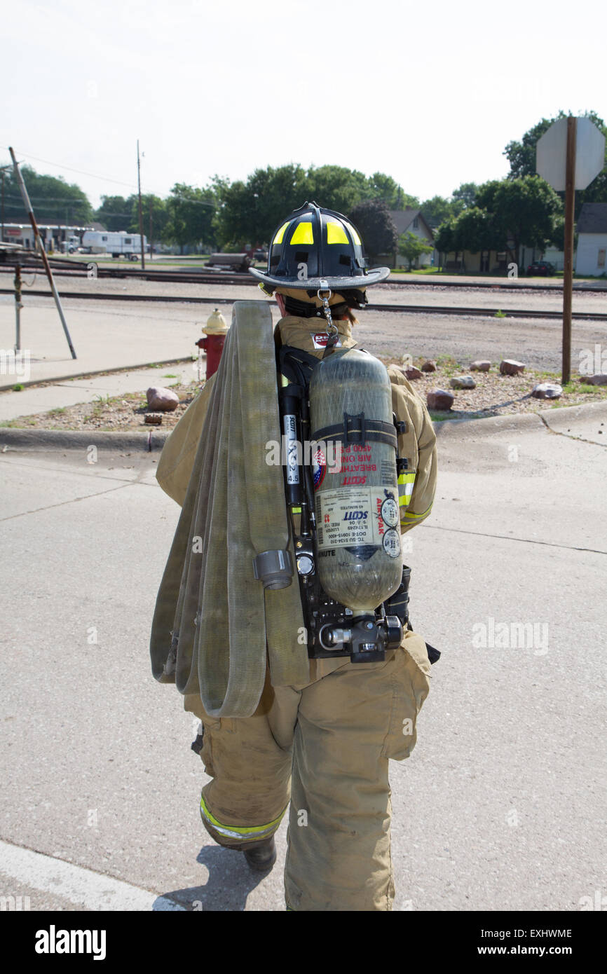 Female firefighter in rural volunteer fire department working with equipment. Stock Photo