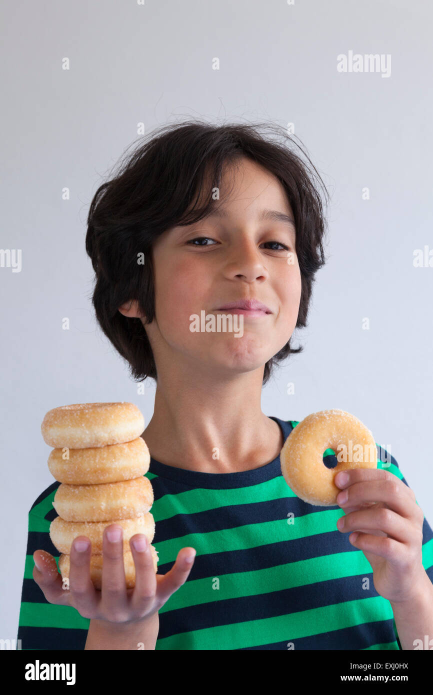 Teenage boy with a pile of donuts on his hand Stock Photo