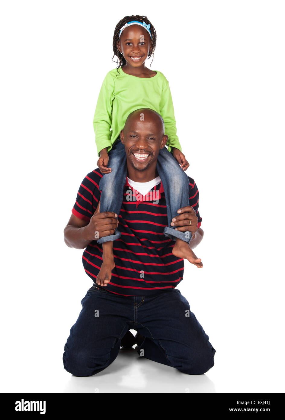 Adorable small african child with braids wearing a bright green shirt and blue jeans is playing with her father. He is wearing a Stock Photo