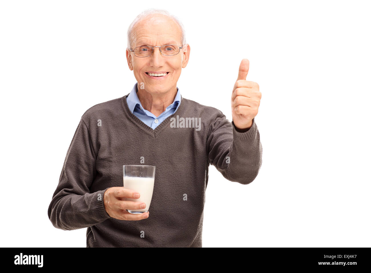 Senior gentleman holding a glass of milk and giving a thumb up isolated ...