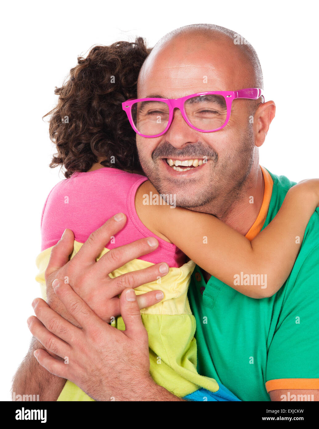 Adorable small caucasian child with curly hair wearing a pink blue and yellow dress. The girl and her father are playing with pi Stock Photo