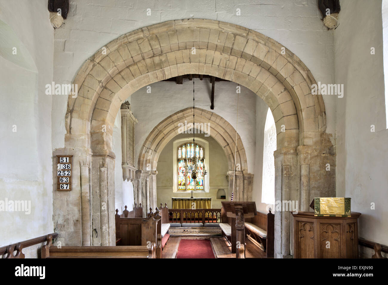 Norman and Perpendicular arches in the Norman church of St James in the Cotswold village of Coln St Dennis, Gloucestershire, UK Stock Photo
