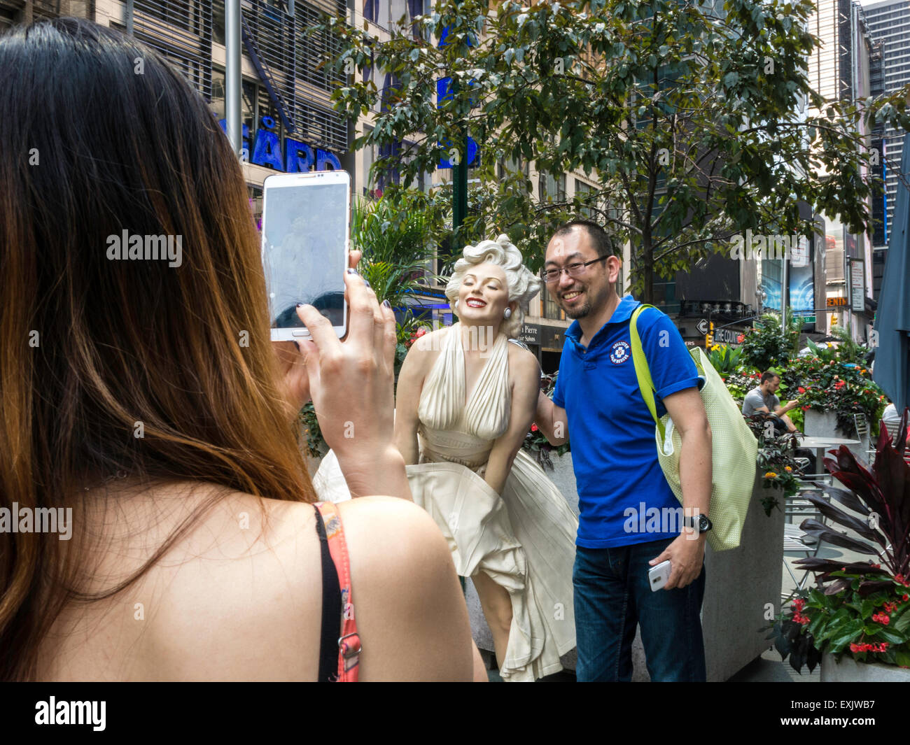Tourists Posing and Taking Photos , Marilyn Monroe Seven year Itch White  dress updraft Statue, Seward Johnson Exhibit, Broadway Pedestrian Plaza Stock Photo