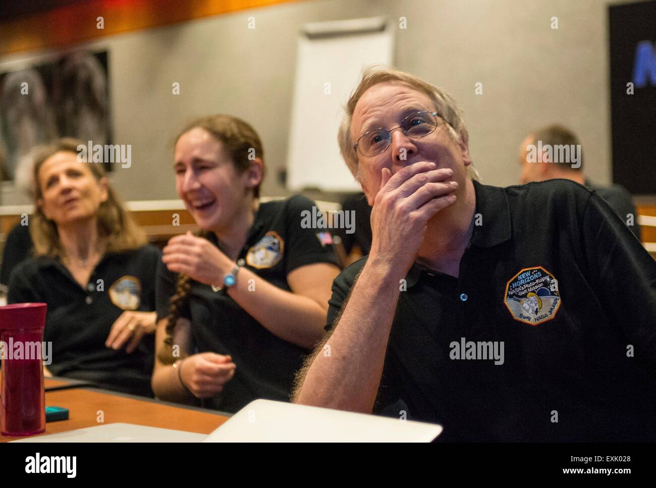 Laurel, Maryland, USA. 14th July, 2015. Members of the New Horizons science team (L-R) SETI Scientist Cristina Dalle Ore, Graduate Student Alissa Earle and Scientist Rick Binzel react to seeing the last and sharpest image of Pluto during the flyby of the space probe at the Johns Hopkins University Applied Physics Laboratory July 14, 2015 in Laurel, Maryland. Stock Photo