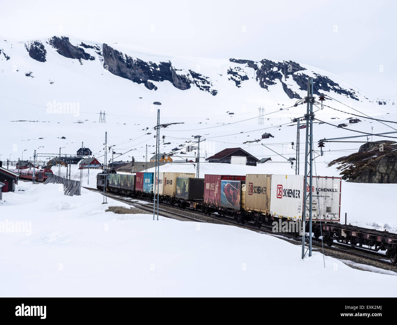 Train passing Finse railway station, area covered wiht snow in late spring, highest railway station on railway Oslo-Bergen Stock Photo