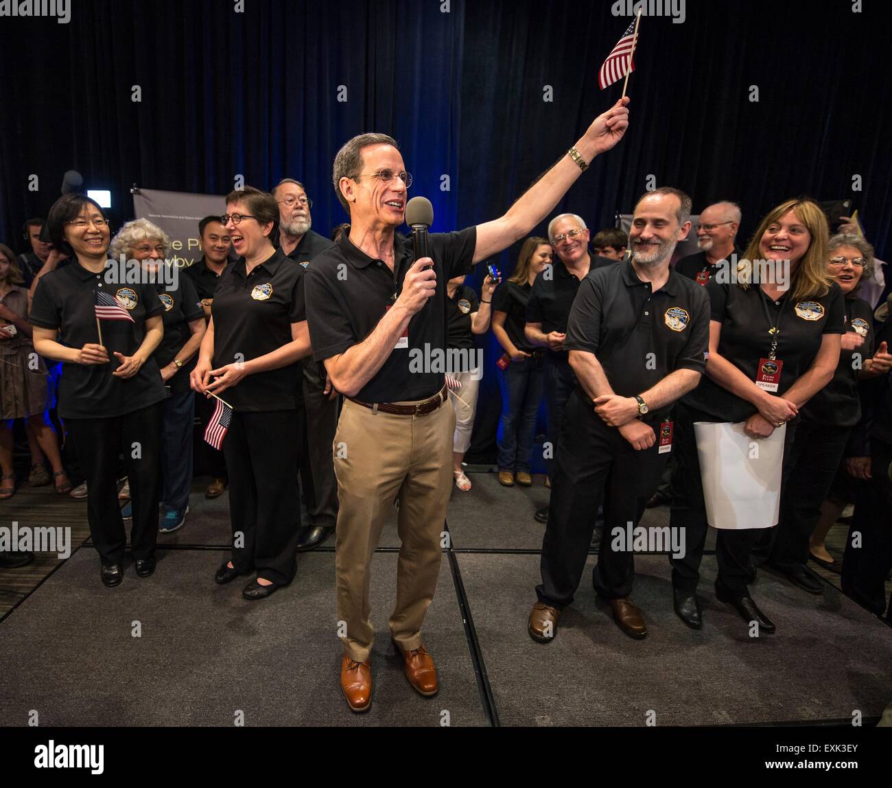 Laurel, Maryland, USA. 14th July, 2015. Johns Hopkins University APL Director Ralph Semmel waves an American flag and praises the hard work of all that worked New Horizons spacecraft after the space probe flyby of Pluto at Johns Hopkins University Applied Physics Laboratory July 14, 2015 in Laurel, Maryland. Stock Photo