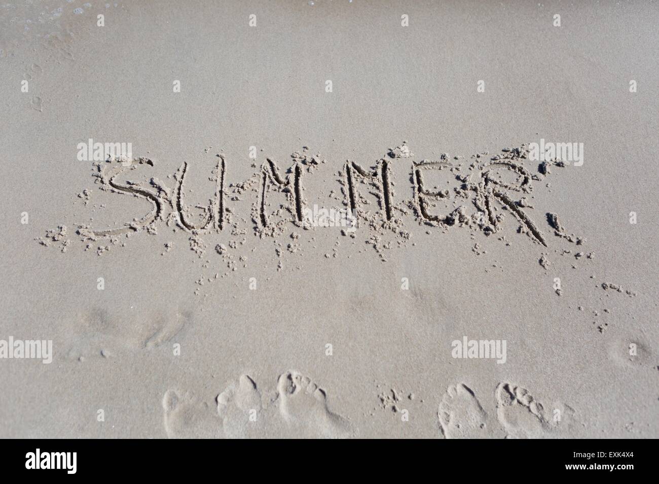 Inscription on beach sand. Sea shore close up with inscription. Summer Stock Photo
