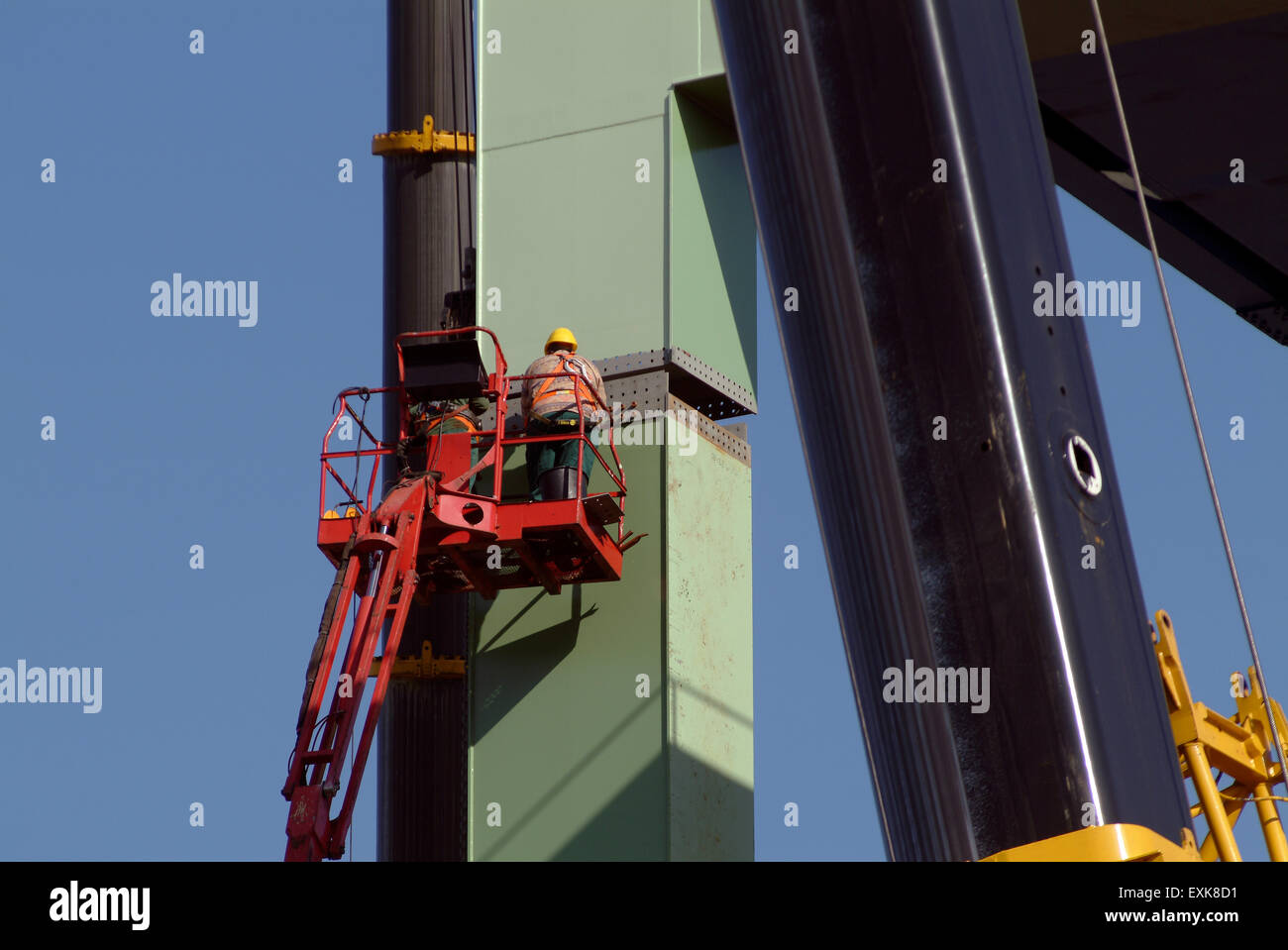 Two Worker installing a metal bridgehead in a harbor Stock Photo