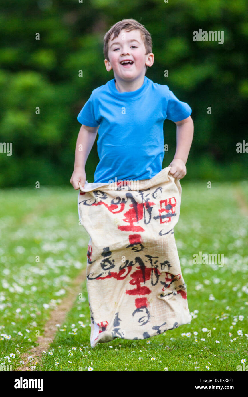 young boy, 4, competing in sack race in pre-school sports day Stock Photo