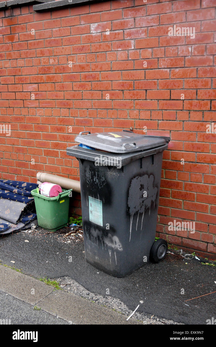 Overloaded Wheelie Bin in a back street in Bolton, Lancashire, Greater Manchester England UK Stock Photo