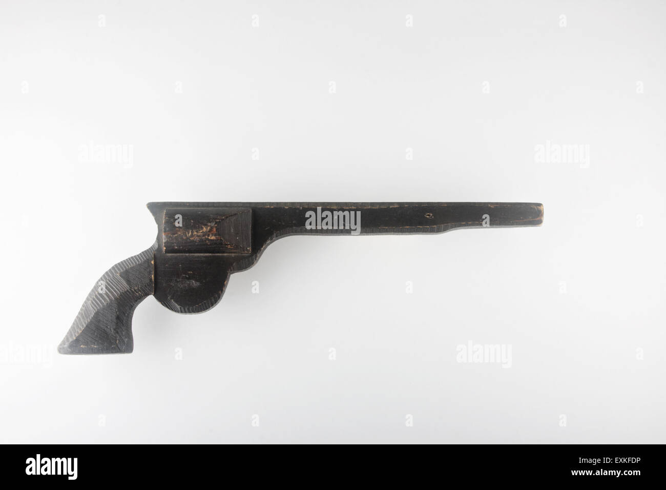 Block out shot of carved wood, toy gun. Stock Photo