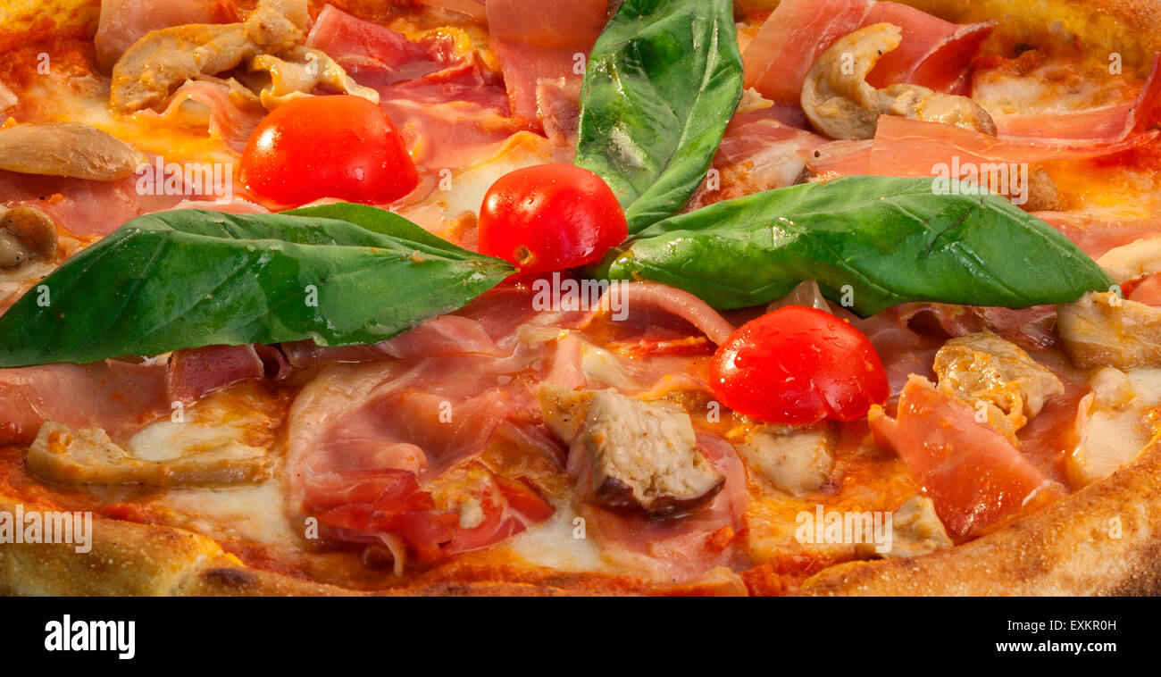 piece of pizza with cheese, cherry tomato and basil Stock Photo