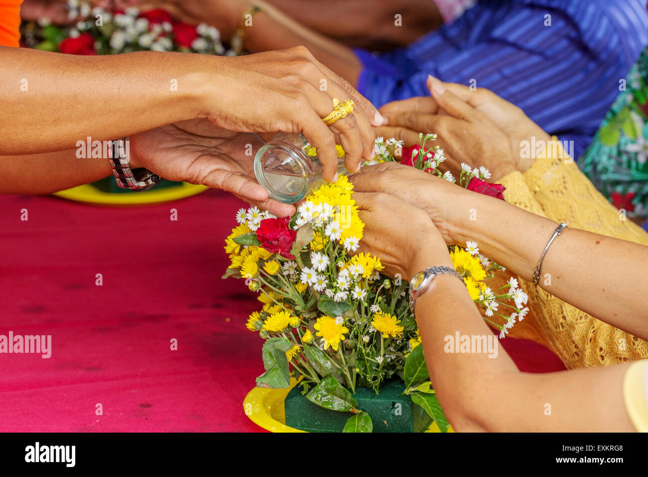 Pour water on the hands of revered elders and gives blessing in
