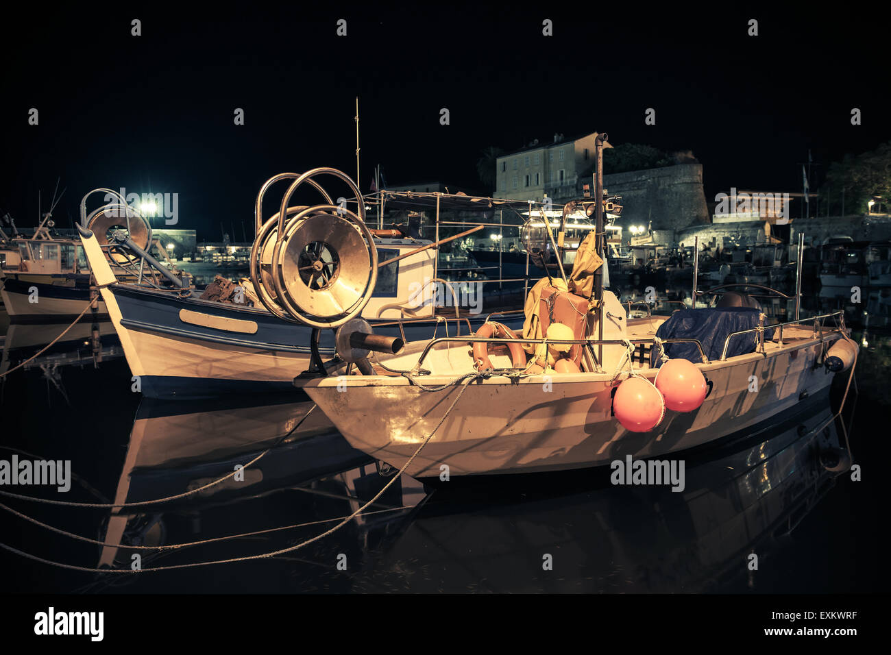 Small wooden fishing boats moored in Ajaccio port, Corsica, France. Vintage toned night photo with old style instagram filter ef Stock Photo
