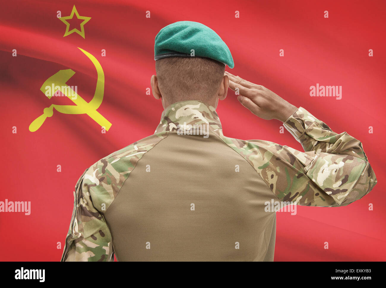 Dark-skinned soldier in hat facing national flag series - USSR - Soviet Union Stock Photo