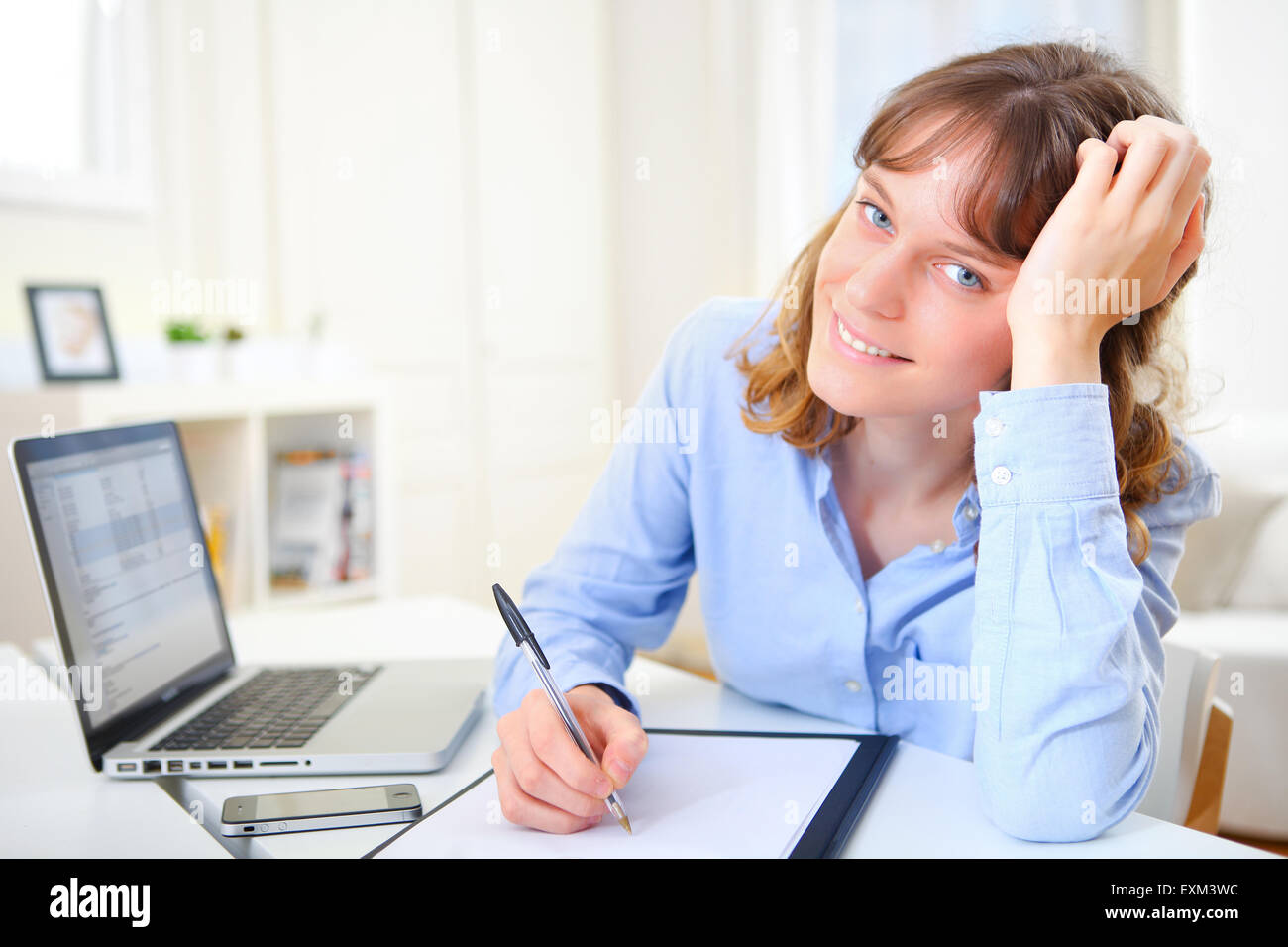 View of a young attractive business woman copying data on paper Stock Photo