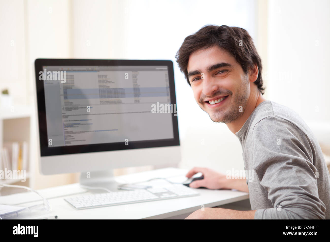 View of a Young smiling man in front of computer Stock Photo - Alamy