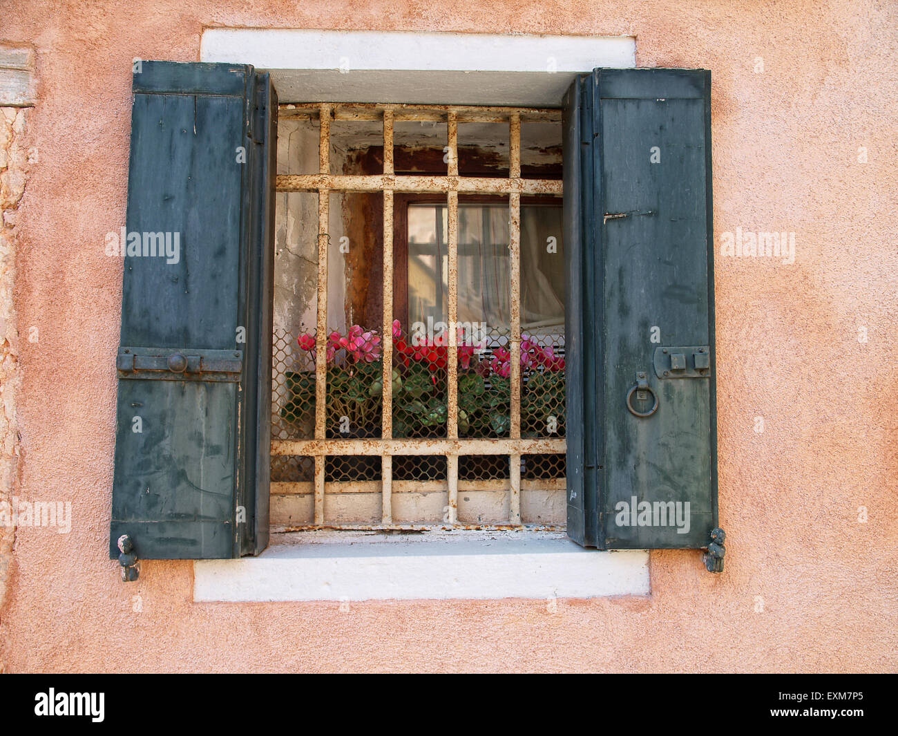 View of a latticed window with green shutters in a old building. Venice. Italy. Stock Photo