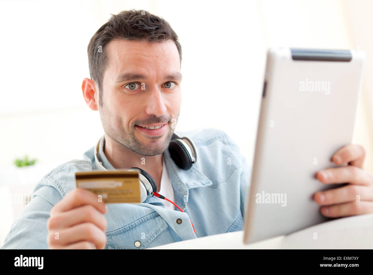 View of a Young relaxed man buying music on tablet Stock Photo