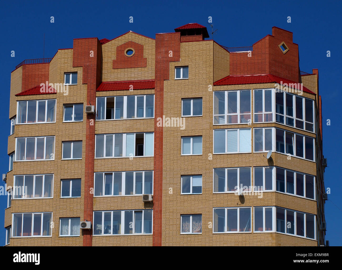 The upper floors of multistory building against the blue sky without clouds Stock Photo