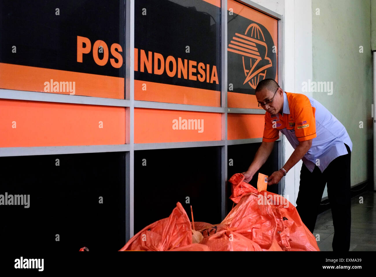 postal worker sorting through sacks of mail at the main post office in malang java indonesia Stock Photo