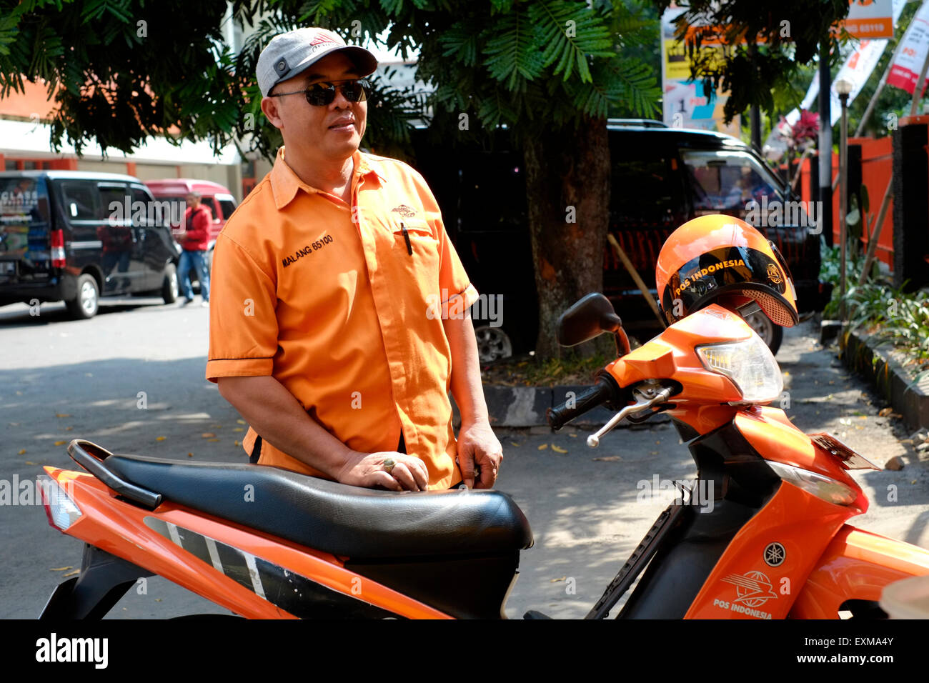 postal worker with company motor bike at the main post office in malang java indonesia Stock Photo