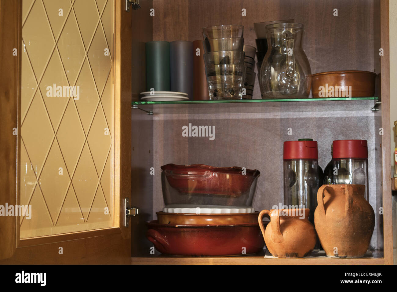 White kitchen cupboard with glasses, cups and bowls. Pastelles Stock Photo  - Alamy