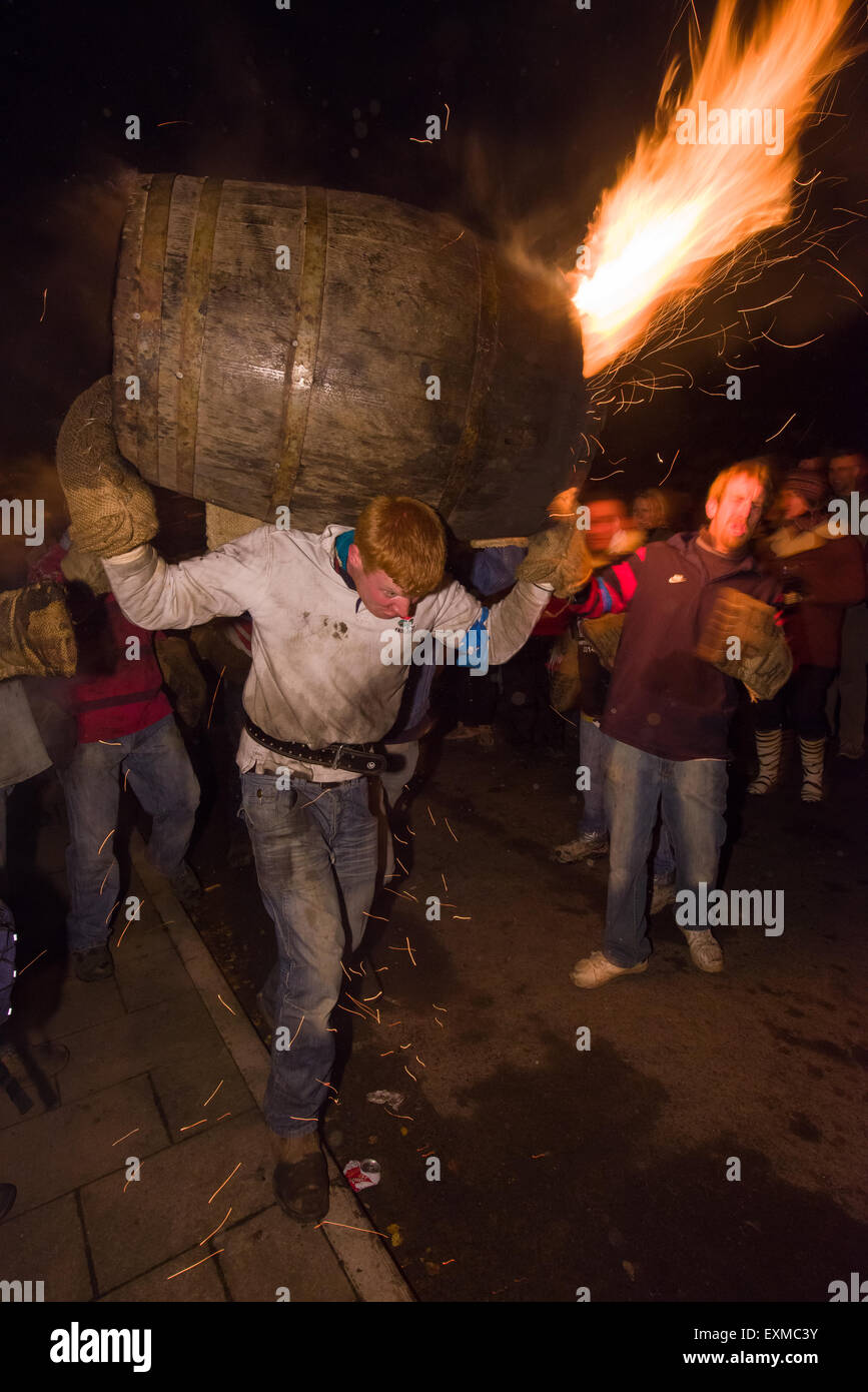Burning barrel being carried through the street to mark Bonfire Night, 5 November, at the Tar Barrels festival, Ottery St Mary, Devon, England Stock Photo