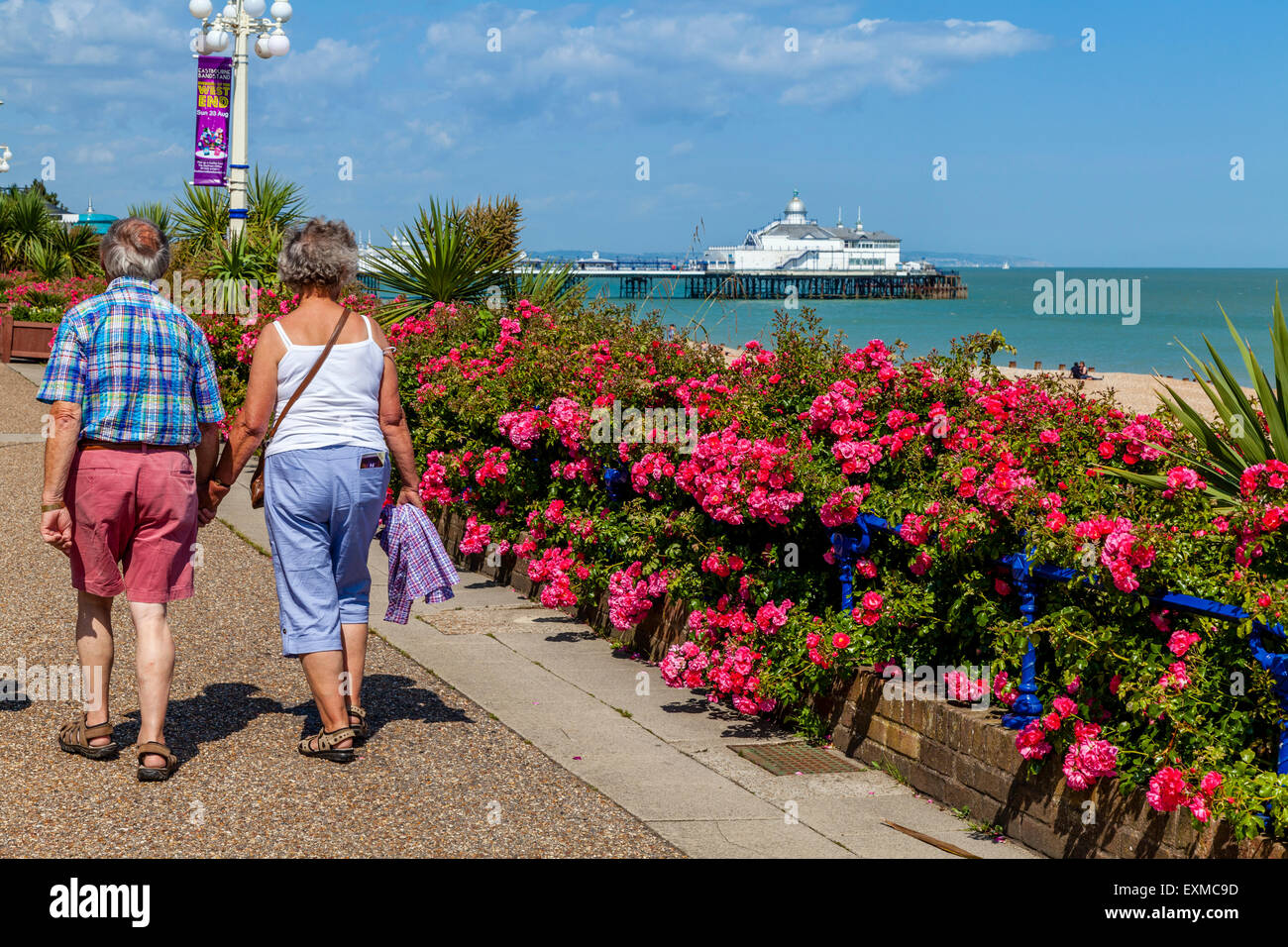 A Couple Walking Along The Seafront, Eastbourne, Sussex, UK Stock Photo