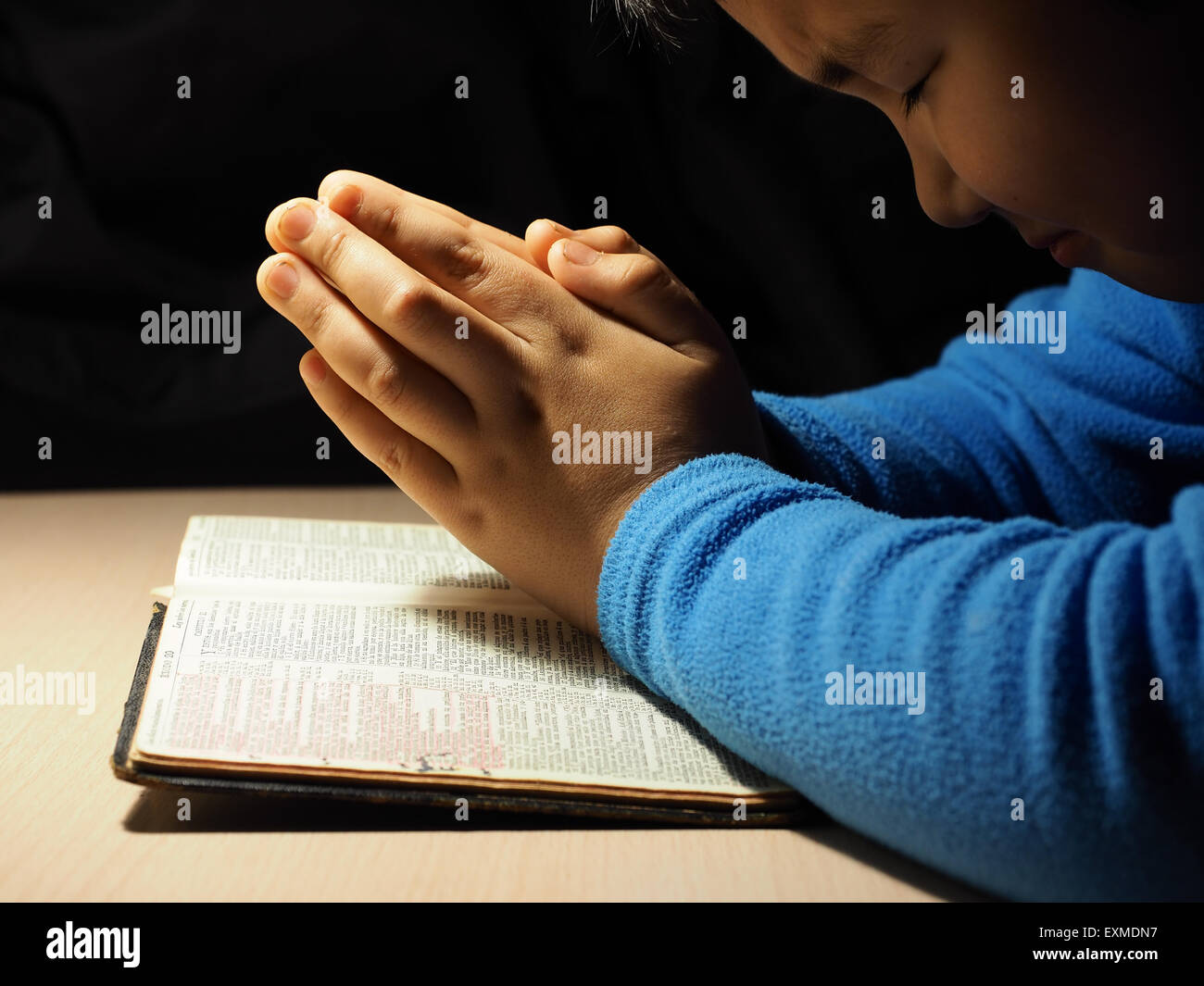 A little boy praying at home Stock Photo