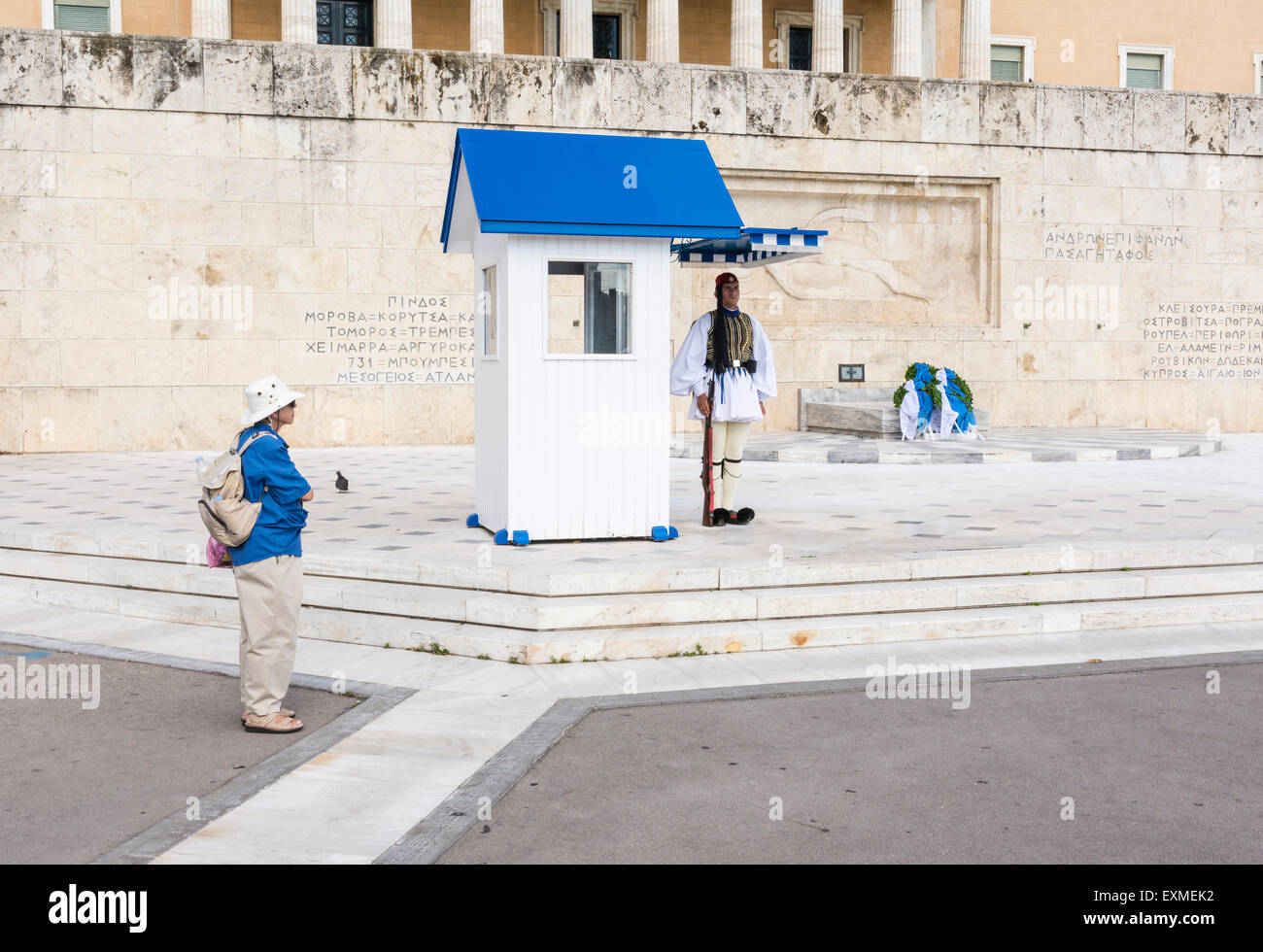 Lone tourist watches a Greek Evzone guard outside Parliament House and the Tomb of the Unknown Soldier, Athens, Greece Stock Photo