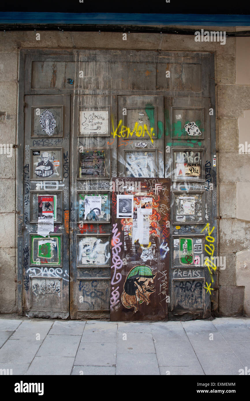 Old door with graffiti, posters, advertisements, notices, leaflets in Barcelona, Spain, Barri Gotic district. Stock Photo